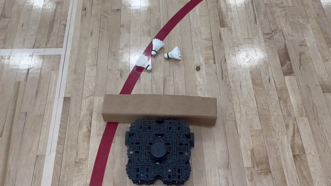 Overhead view of the robot with a cardboard collection ramp approaching shuttlecocks on court