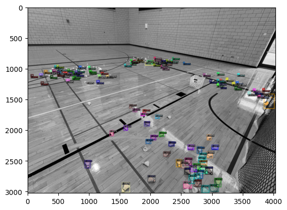 Bounding boxes with class labels and confidence scores over shuttlecocks scattered across a gymnasium