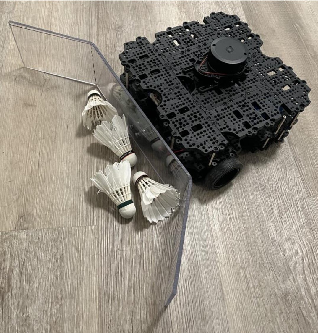 The collection robot next to three badminton shuttlecocks on a wood floor